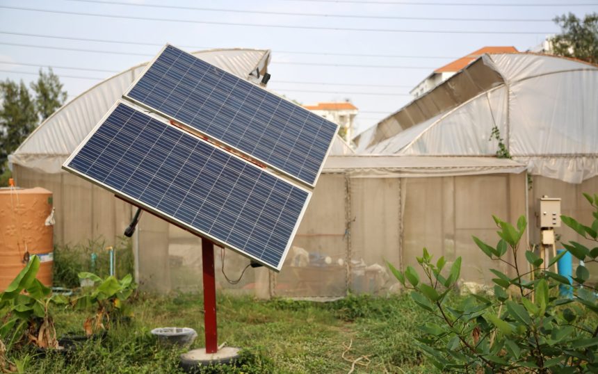 Solar panels (solar cell) in solar farm with blue sky and sun lighting.